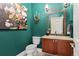 Stylish powder room with elegant wall art, vanity, decorative mirror, and sconce lighting at 2486 S Monroe St, Denver, CO 80210