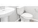 Clean bathroom featuring a pedestal sink and toilet with wood-look tile flooring at 763 N Tibet St, Aurora, CO 80018