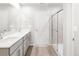 Elegant bathroom featuring double sinks, gray cabinetry, and a modern glass shower with light wood flooring at 763 N Tibet St, Aurora, CO 80018
