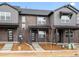 Contemporary townhome featuring a brick facade, covered porch, and modern door design at 763 N Tibet St, Aurora, CO 80018