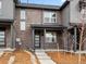 Contemporary townhome featuring a brick facade, covered porch, and modern door design at 763 N Tibet St, Aurora, CO 80018