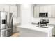 Modern kitchen with stainless steel appliances, white cabinets, and a center island at 763 N Tibet St, Aurora, CO 80018