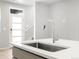 A modern kitchen sink with a stainless steel faucet sits atop a sleek countertop near a door at 763 N Tibet St, Aurora, CO 80018