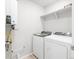 Efficient laundry area with modern washer, dryer, and built-in shelves for storage at 763 N Tibet St, Aurora, CO 80018