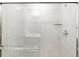 Modern tiled walk-in shower featuring a glass door, chrome fixtures, and a built-in glass shelf at 763 N Tibet St, Aurora, CO 80018