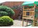 Backyard with a custom wooden playset, lush landscaping, and a rock wall at 155 Xenon St # 33, Denver, CO 80228