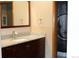 Bathroom with dark wood cabinets, granite counters, and decorative mirror at 155 Xenon St # 33, Denver, CO 80228