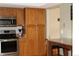 Kitchen with stainless steel appliances, oak cabinets, and a breakfast bar at 155 Xenon St # 33, Denver, CO 80228