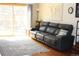 Bright living room features a leather couch and a sliding glass door to a backyard area at 155 Xenon St # 33, Denver, CO 80228