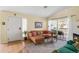 Cozy living room with a brown leather couch, fireplace, sliding glass door to balcony, rug, and bright natural light at 8405 Pebble Creek Way # 202, Highlands Ranch, CO 80126