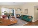 Inviting living room with fireplace, modern green sofa, leather couch, rug, and access to balcony for outdoor views at 8405 Pebble Creek Way # 202, Highlands Ranch, CO 80126