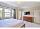 Bright bedroom with large windows, a mounted TV, and a wooden dresser at 10152 Inverness Main St, Englewood, CO 80112