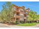 Charming multi-story condo with stone accents, lush landscaping, and signage at the corner of Oak Street at 10152 Inverness Main St, Englewood, CO 80112