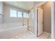Bright bathroom with a white tiled shower, soaking tub, and access to the room at 3573 S Lisbon Ct, Aurora, CO 80013