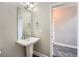 Powder room featuring a pedestal sink with a large mirror and dark wood-style flooring at 3573 S Lisbon Ct, Aurora, CO 80013