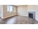 Spacious living room with gray wood floors, a corner fireplace, and a large window at 3573 S Lisbon Ct, Aurora, CO 80013