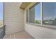 View of the exterior patio with neutral siding, a window, and wood-style flooring at 3573 S Lisbon Ct, Aurora, CO 80013