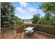 Large wooden deck with railings providing stunning views of the surrounding green landscape at 2527 S Ouray Way, Aurora, CO 80013