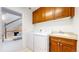 Bright laundry room with sink and storage, including front loading washer and dryer at 203 S Jackson St, Denver, CO 80209