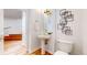 Stylish powder room with pedestal sink, gold fixtures, and modern wall art at 203 S Jackson St, Denver, CO 80209