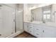 Bathroom with double vanity, large mirror, and walk-in shower at 8570 Eagle River St, Littleton, CO 80125