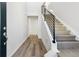 Modern entryway with gray vinyl plank flooring and a metal railing staircase at 8570 Eagle River St, Littleton, CO 80125