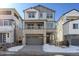 Two-story home with gray siding, stone accents, and a two-car garage at 8570 Eagle River St, Littleton, CO 80125