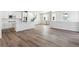 Open concept kitchen with island, white cabinets, and gray vinyl plank floors at 8570 Eagle River St, Littleton, CO 80125