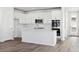Modern white kitchen with stainless steel appliances and an island at 8570 Eagle River St, Littleton, CO 80125