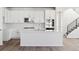 Modern white kitchen with stainless steel appliances and an island at 8570 Eagle River St, Littleton, CO 80125
