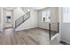 Bright living room with gray vinyl plank flooring and a metal railing staircase at 8570 Eagle River St, Littleton, CO 80125