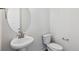 Small powder room with pedestal sink and oval mirror at 8570 Eagle River St, Littleton, CO 80125