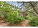 Landscaped backyard featuring a screened in porch surrounded by lush trees, bushes, and a brick pathway at 10284 Royal Eagle St, Highlands Ranch, CO 80129