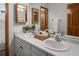 Well-lit bathroom with double sinks, vanity, and wood-trimmed mirrors at 10284 Royal Eagle St, Highlands Ranch, CO 80129