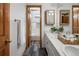 Stylish bathroom featuring double vanity with wood accents, and bright natural lighting at 10284 Royal Eagle St, Highlands Ranch, CO 80129