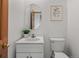 Neutral half-bathroom featuring a modern vanity, oval mirror, and classic framed artwork at 10284 Royal Eagle St, Highlands Ranch, CO 80129