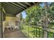 Relaxing covered balcony with wrought iron railing overlooking lush green lawn and mature trees at 2665 S Sheridan Ct, Lakewood, CO 80227