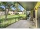 Private balcony with iron fencing offering views of a grassy common area and mature trees at 2665 S Sheridan Ct, Lakewood, CO 80227