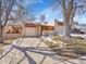 Front view of ranch home with driveway and mature trees at 2665 S Sheridan Ct, Lakewood, CO 80227