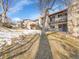 Back exterior view of the property, showing landscaping and snow at 2665 S Sheridan Ct, Lakewood, CO 80227