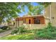 Charming brick townhome with mature trees, covered porch, and well-manicured lawn at 2665 S Sheridan Ct, Lakewood, CO 80227