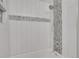 Updated shower stall with white tiling and mosaic accent stripe at 2665 S Sheridan Ct, Lakewood, CO 80227