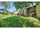 Expansive green lawn with mature trees surrounding the brick condo building at 2665 S Sheridan Ct, Lakewood, CO 80227