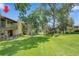 Lush green lawn with mature trees surrounding the brick condo building at 2665 S Sheridan Ct, Lakewood, CO 80227