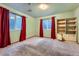 Bedroom with carpeting, two windows with red curtains and a built-in bookcase at 6526 S Killarney Ct, Aurora, CO 80016