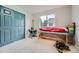 Carpeted bedroom with a light blue closet door, exercise equipment, and a large window at 6526 S Killarney Ct, Aurora, CO 80016