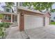 Home with a brick facade, featuring a spacious garage with white doors and concrete driveway at 6526 S Killarney Ct, Aurora, CO 80016