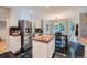 Eat-in kitchen with stainless steel refrigerator, center island, and black tile floors at 6526 S Killarney Ct, Aurora, CO 80016