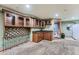 Living room with carpet, built-in bar with upper glass cabinets and sink at 6526 S Killarney Ct, Aurora, CO 80016
