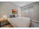 Cozy bedroom featuring a bed with blue pillows, side tables, and a snowy view from the window at 726 Dreamcatcher Ln, Evergreen, CO 80439